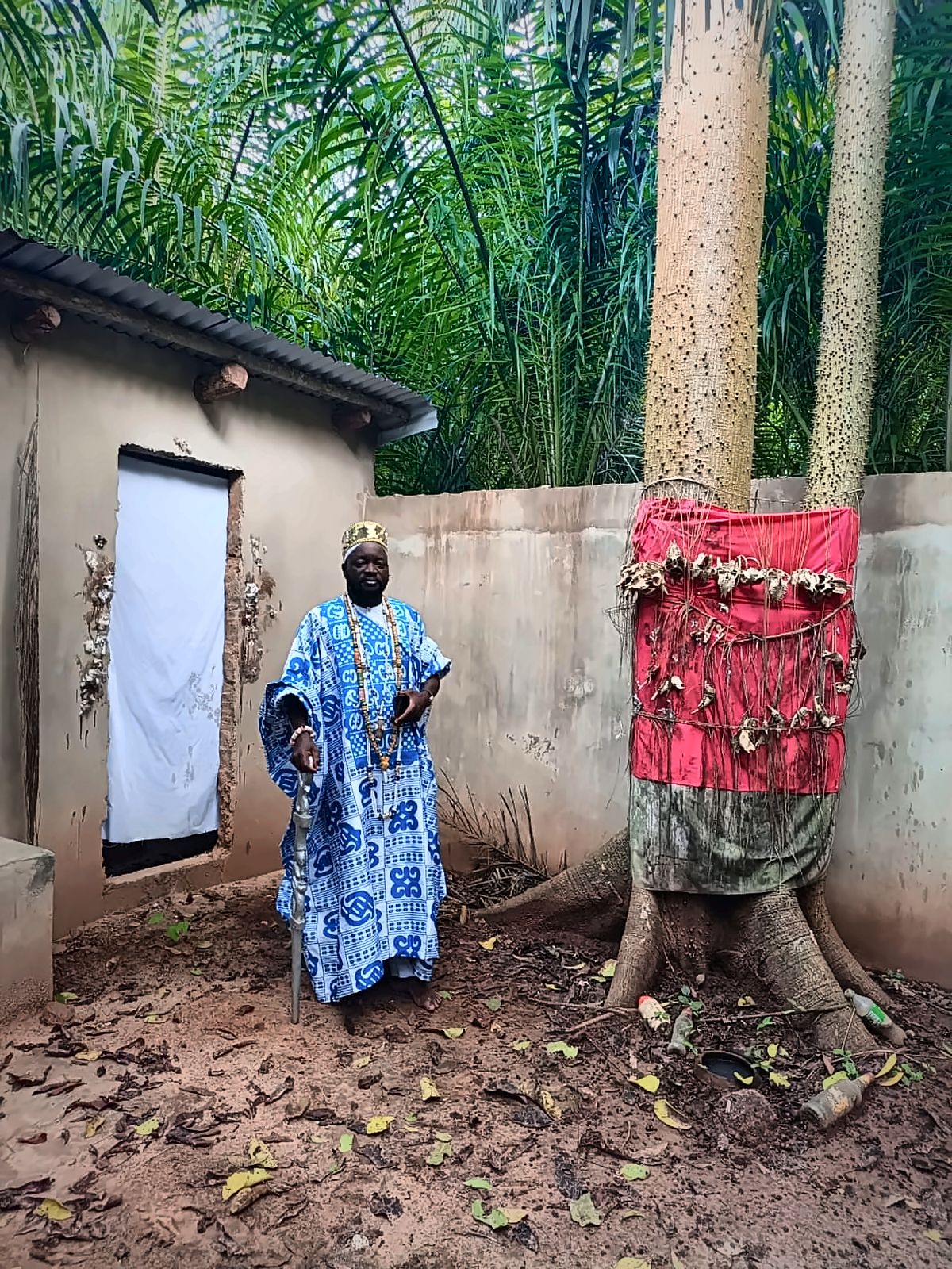 Le Maître Djanminnou Hossou devant l'arbre sacré du couvent