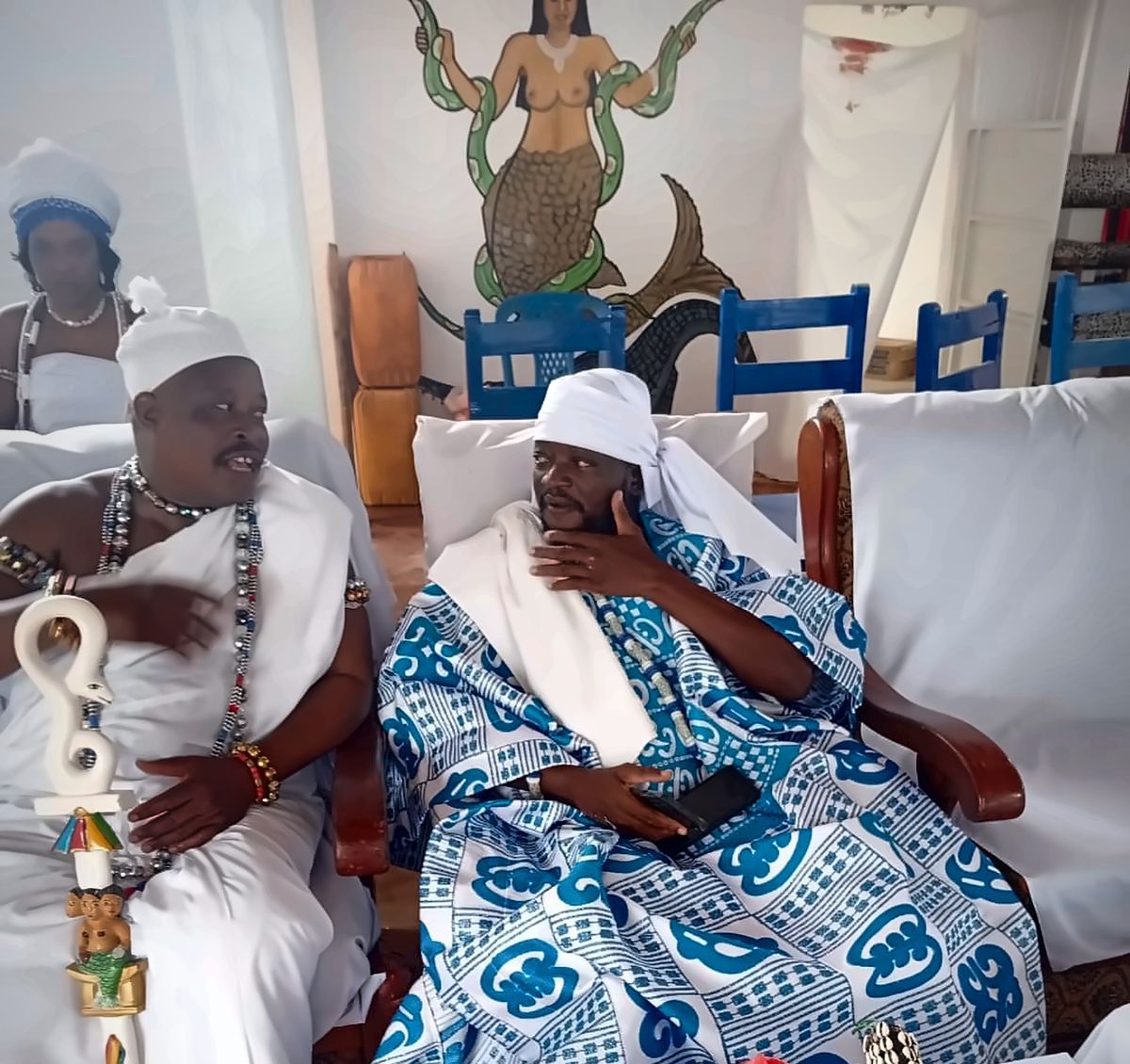 Le Maître Djanminnou Hossou en conseil au couvent, devant la fresque de Mami Wata